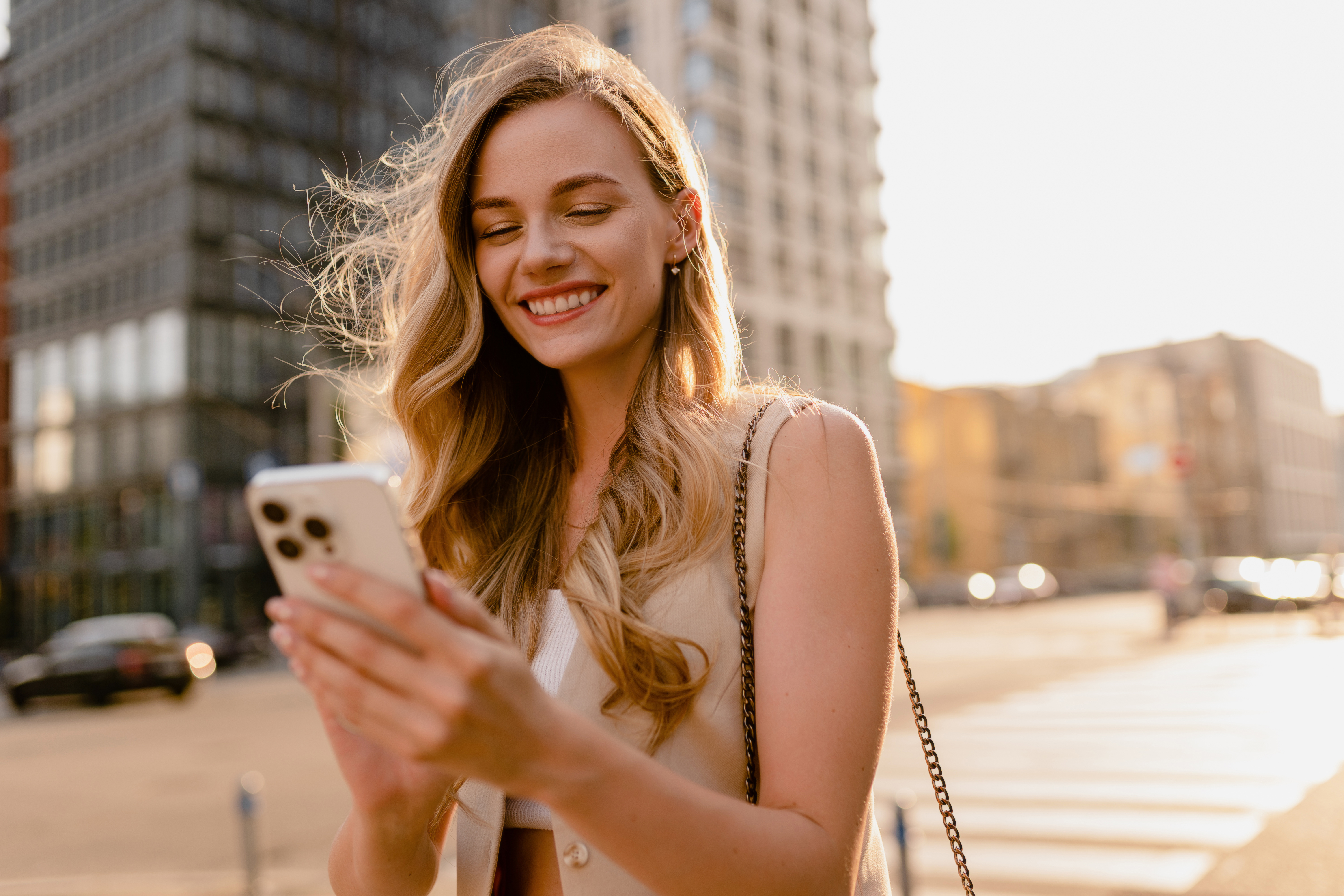 Smiling rider using a phone on a city street